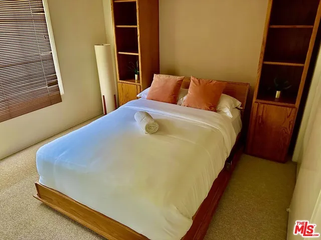 a blue bed sitting in a bedroom next to a window