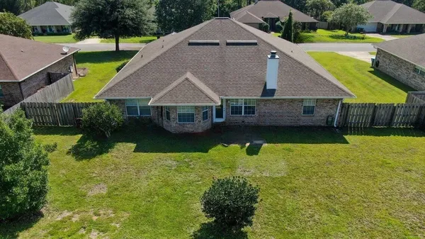 a aerial view of a house with a yard table and chairs