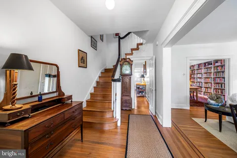 a view of a hallway with furniture and wooden floor