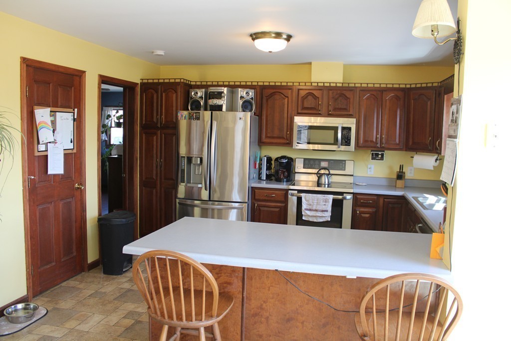 206 East Colrain Road Colrain, MA 01340 - Photo 4 of 27 a kitchen with stainless steel appliances granite countertop a refrigerator a sink a stove a dining table and chairs