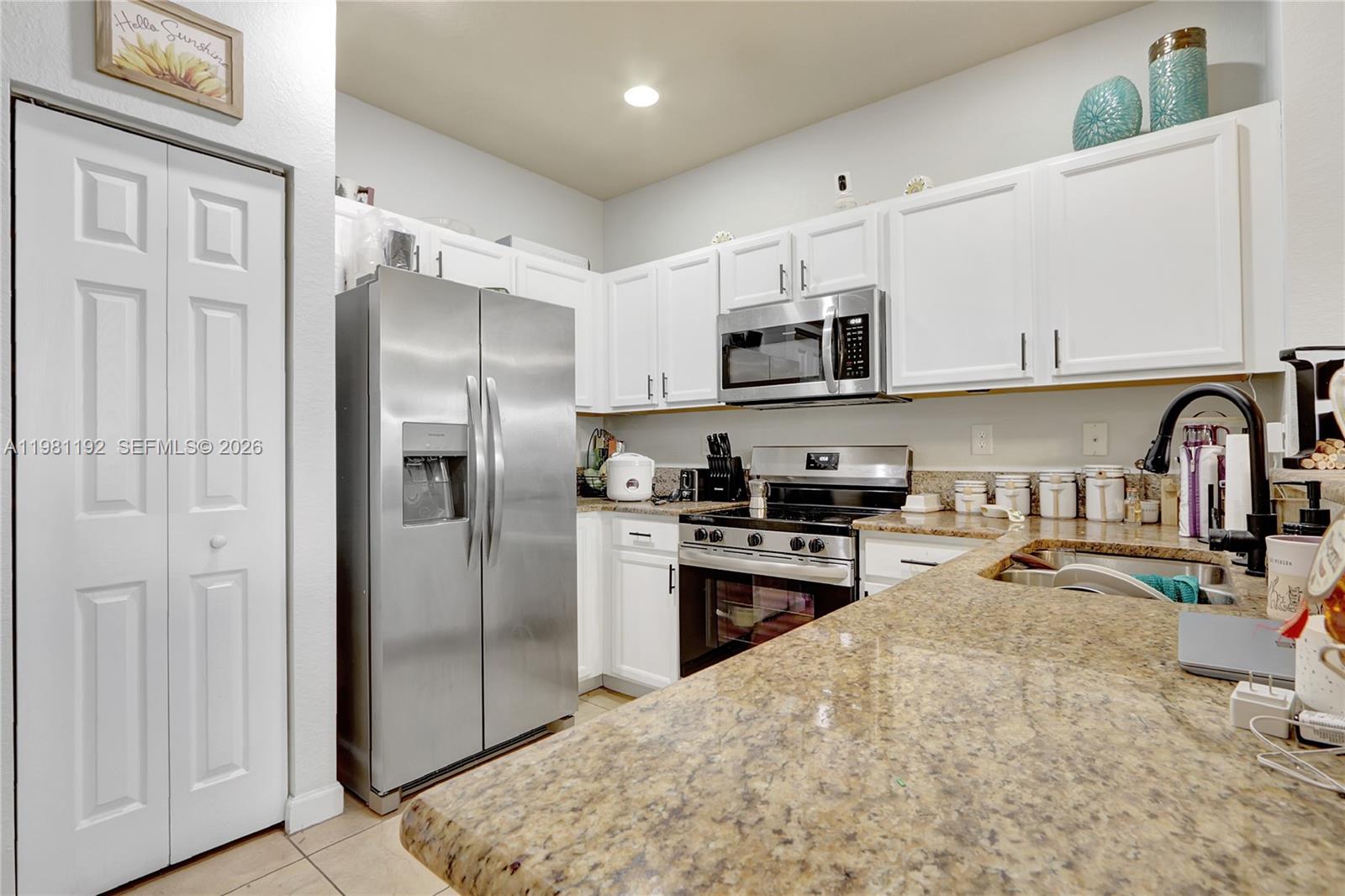 338 Northeast 37th Avenue Homestead, FL 33033 - Photo 5 of 19 a kitchen with stainless steel appliances granite countertop a refrigerator and a stove top oven