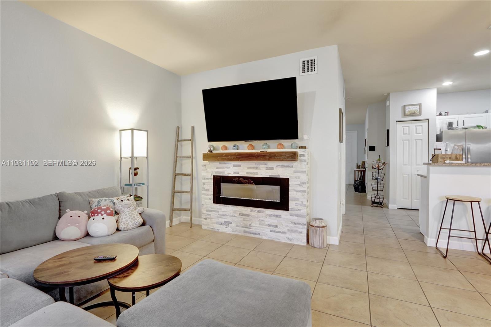 338 Northeast 37th Avenue Homestead, FL 33033 - Photo 7 of 19 a living room with furniture a flat screen tv and a fireplace