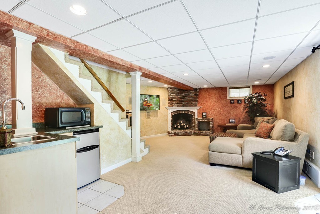 19 Bare Hill Road Boxford, MA 01921 - Photo 23 of 30 a living room with furniture a fireplace and a flat screen tv