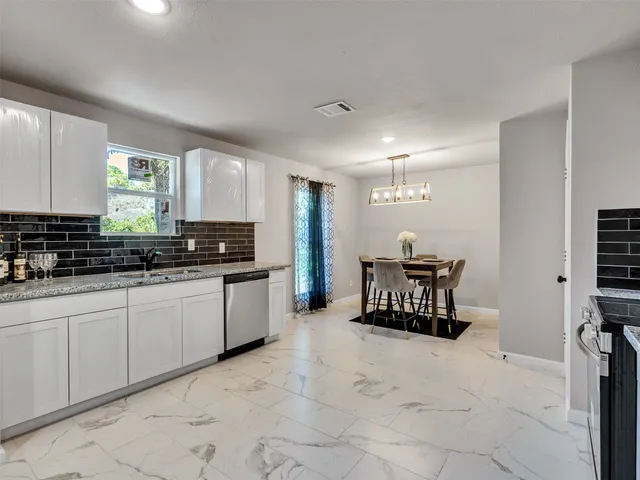 a large white kitchen with a large window