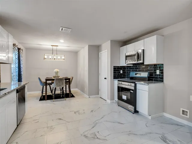 a kitchen with stainless steel appliances a stove a sink a microwave and a refrigerator