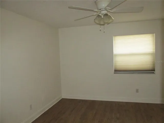 an empty room with a window and a ceiling fan