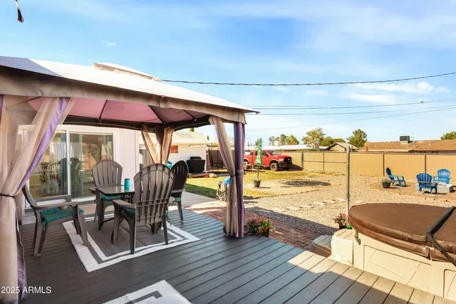 a view of deck with table and chairs under an umbrella