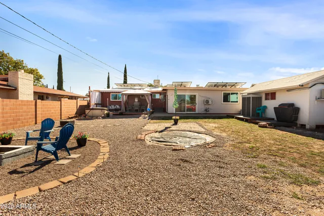 a swimming pool with barbeque oven table and chairs