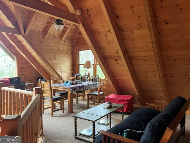 a view of an empty room with wooden floor and windows