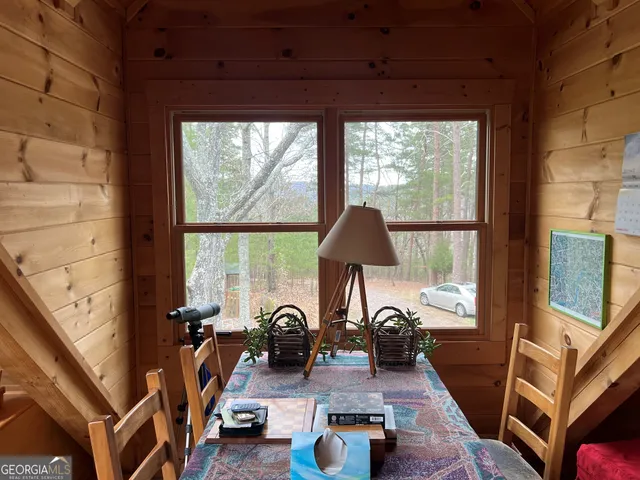 a dining room with wooden floor table and chairs