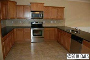 274 Ranlo Avenue Gastonia, NC 28054 - Photo 3 of 8 a kitchen with granite countertop a stove top oven microwave and cabinets