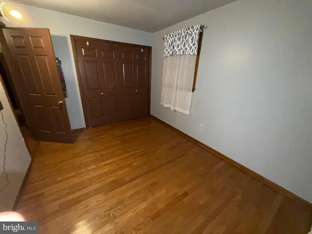 a view of a closet area with wooden floor