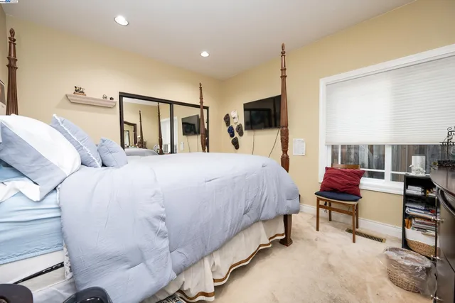 a spacious bedroom with a bed and wooden floor