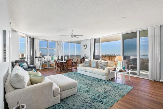 a living room with furniture kitchen view and a large window
