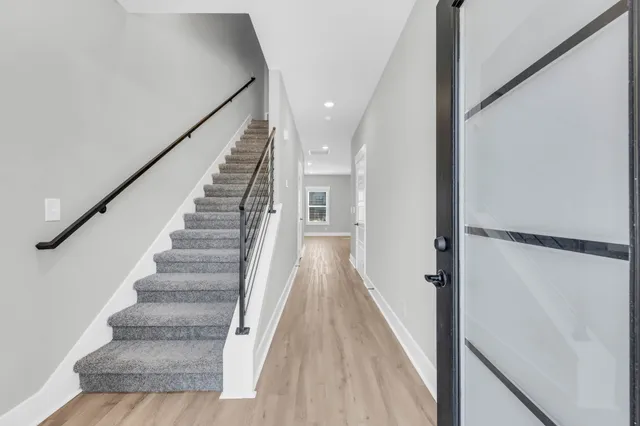 a view of a hallway with wooden floor and staircase
