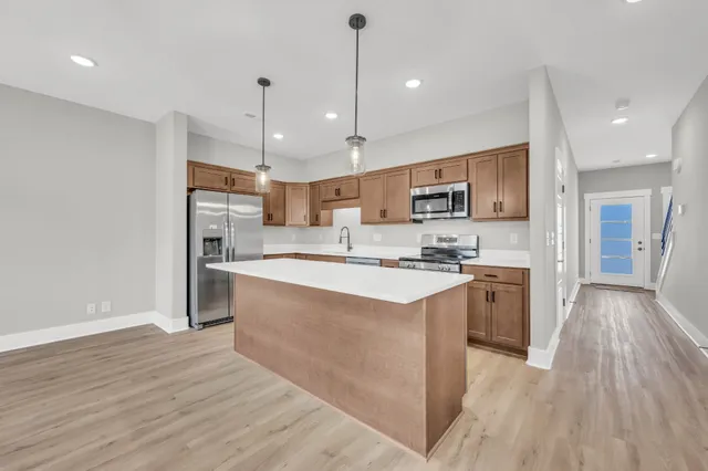 a large kitchen with stainless steel appliances granite countertop a stove a sink and a refrigerator