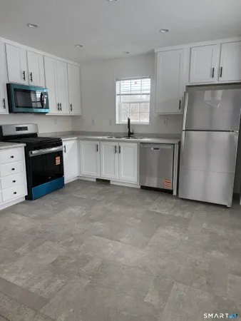 a kitchen with white cabinets and stainless steel appliances
