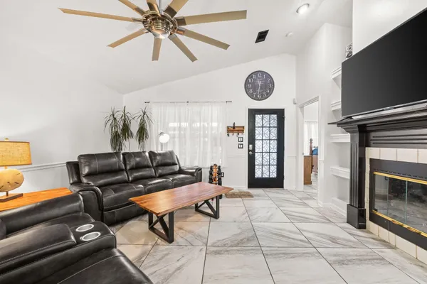 a living room with furniture a clock and a flat screen tv