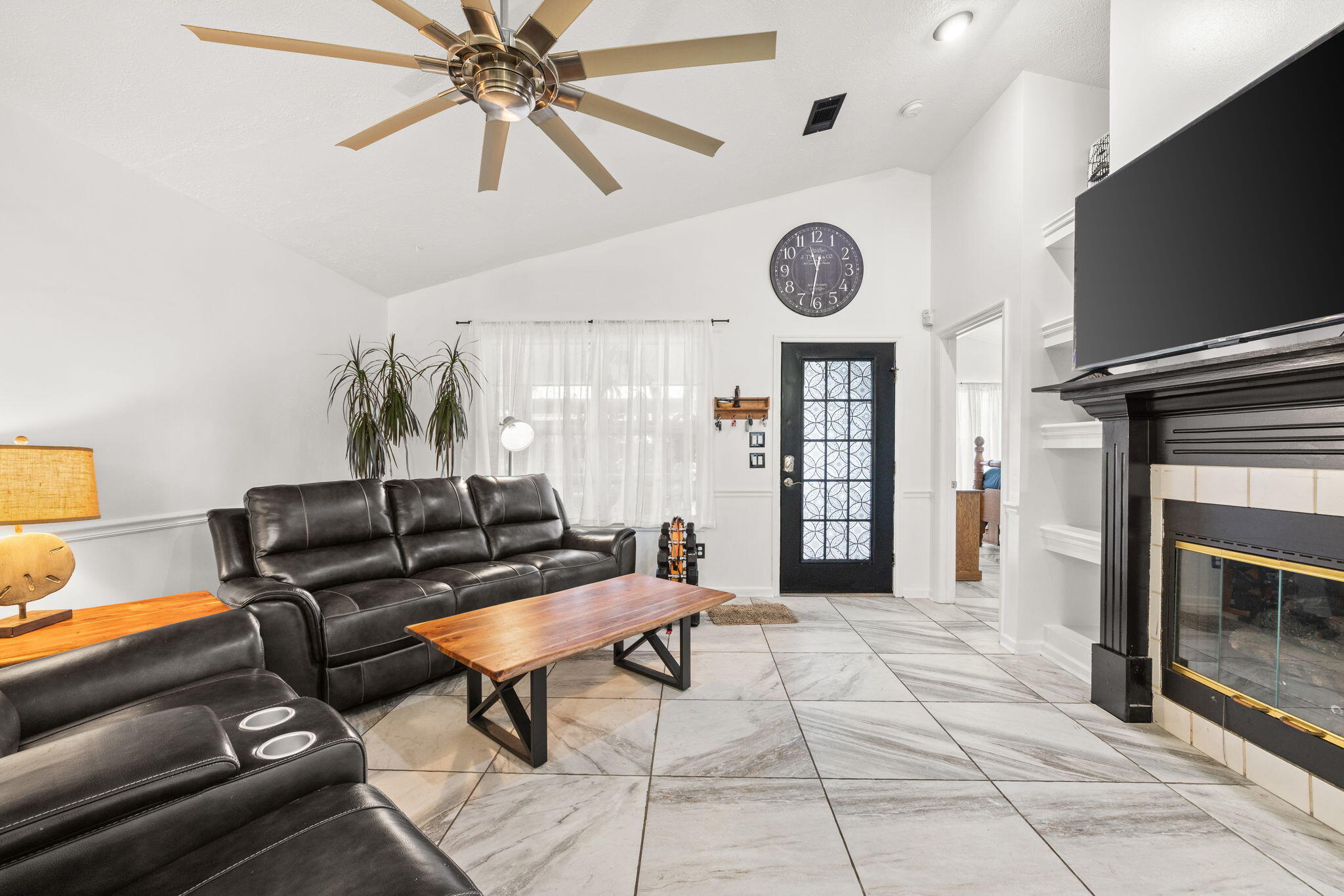 17826 Front Beach Road Panama City Beach, FL 32413 - Photo 11 of 34 a living room with furniture a clock and a flat screen tv
