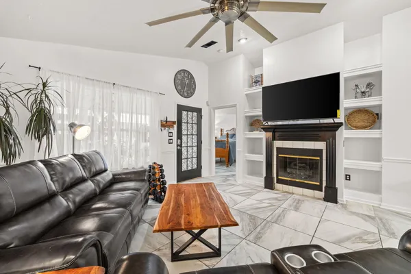 a living room with furniture a flat screen tv and a fireplace