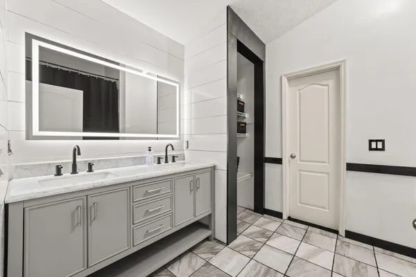 a bathroom with a double vanity sink and a mirror