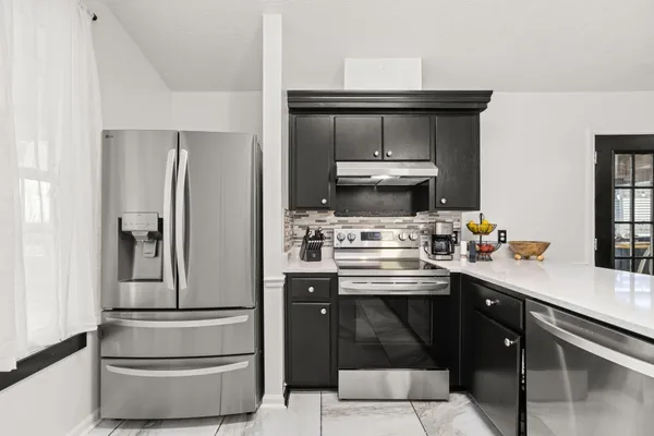 a kitchen with stainless steel appliances a stove and refrigerator