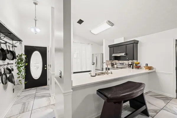 a kitchen with a sink a stove and chairs