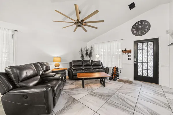 a living room with furniture a clock and a window