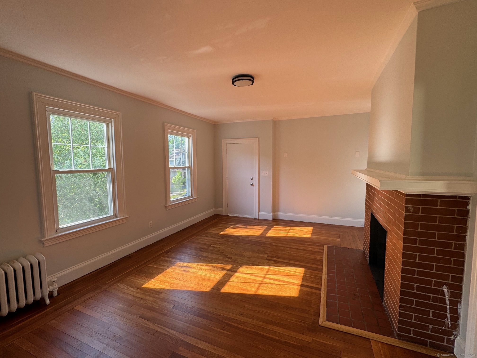 1253 Forest Road, Unit 2 New Haven, CT 06515 - Photo 9 of 30 a view of an empty room with window and wooden floor