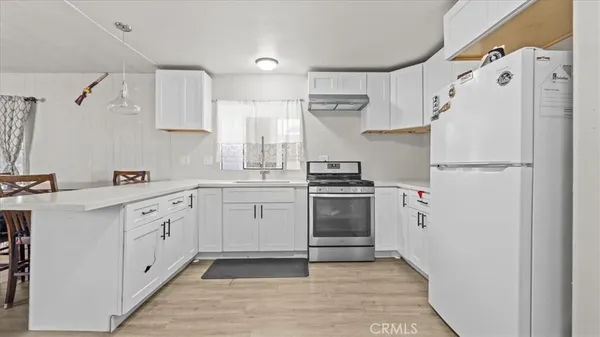 a kitchen with white cabinets and white appliances