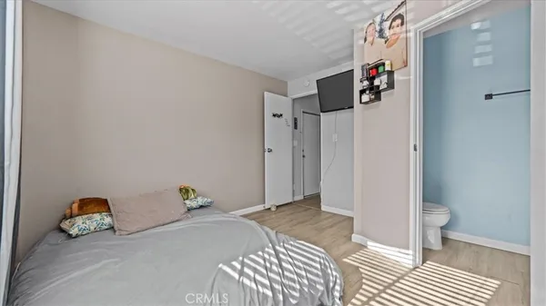 a view of a bedroom with wooden floor and closet