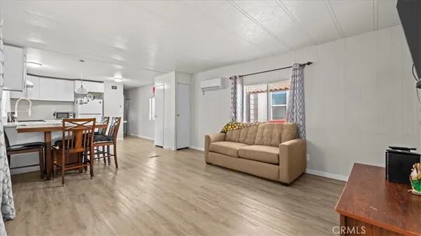 a living room with furniture and a dining table with wooden floor