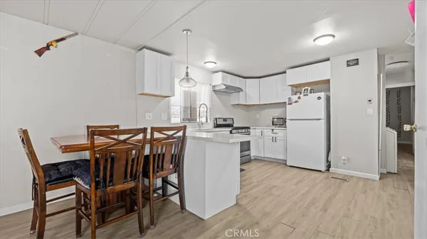 a kitchen with a table chairs refrigerator and cabinets