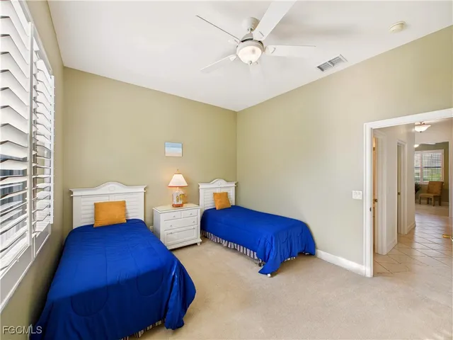 a bedroom with two beds and painting on the wall