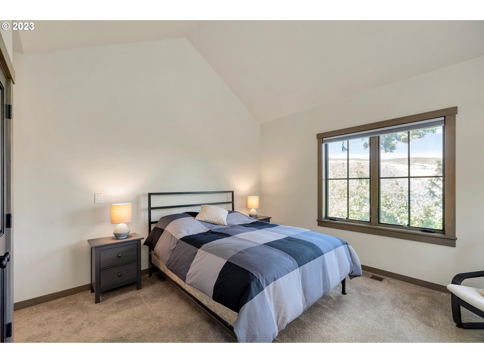 915 Fifth Avenue Mosier, OR 97040 - Photo 12 of 34 a bedroom with a bed lamp and a window