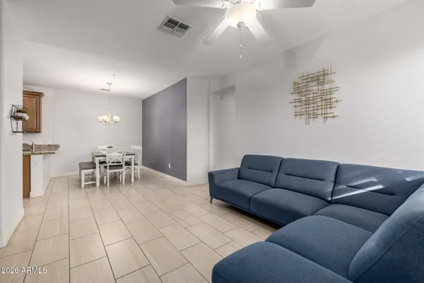 a living room with furniture and a dining table with kitchen view
