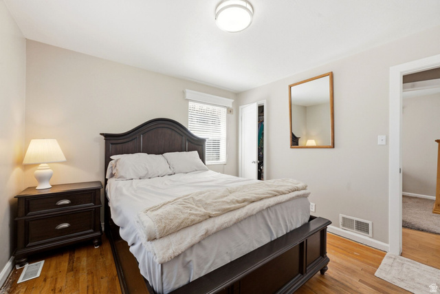 310 East 600 South Centerville, UT 84014 - Photo 13 of 41 Bedroom featuring wood-finish flooring, light-toned walls, a ceiling-mounted light fixture, and a window with blinds