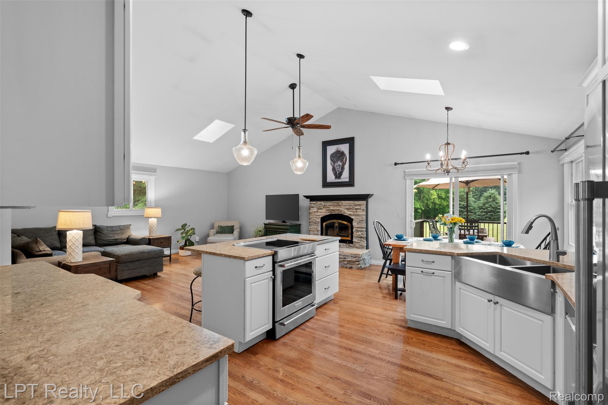 2588 East Jones Road Howell, MI 48855 - Photo 38 of 40 Kitchen featuring open floor plan, a skylight, hanging lights, light wood-type flooring, and a ceiling fan