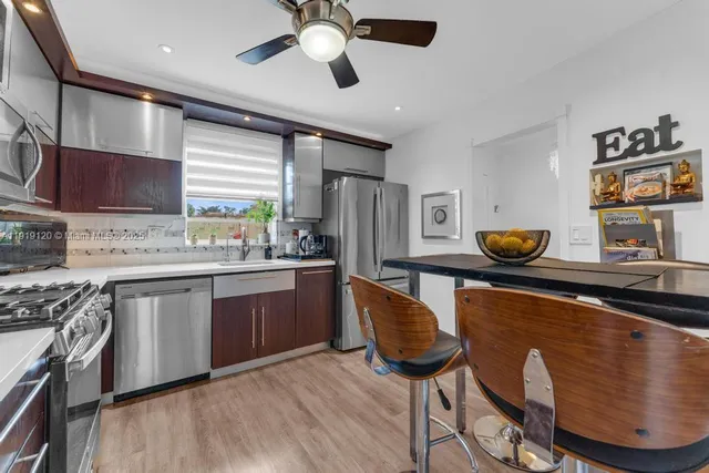 a kitchen with stainless steel appliances granite countertop a sink a stove and a refrigerator