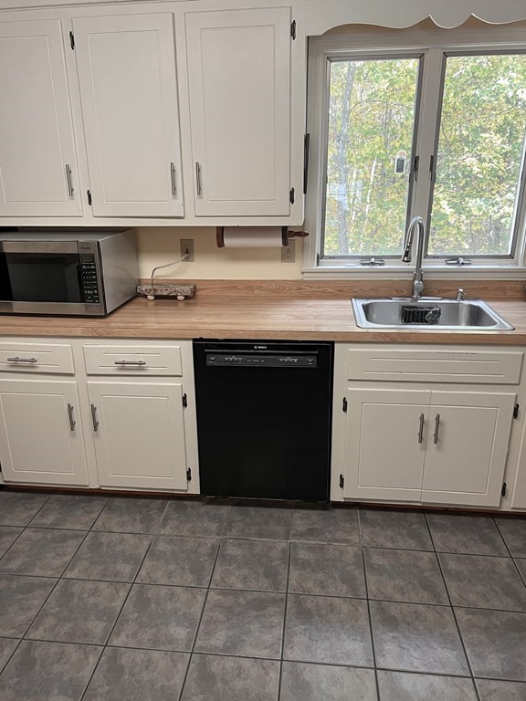 35 Robert Road Tyngsborough, MA 01879 - Photo 16 of 25 a kitchen with a sink stove and cabinets