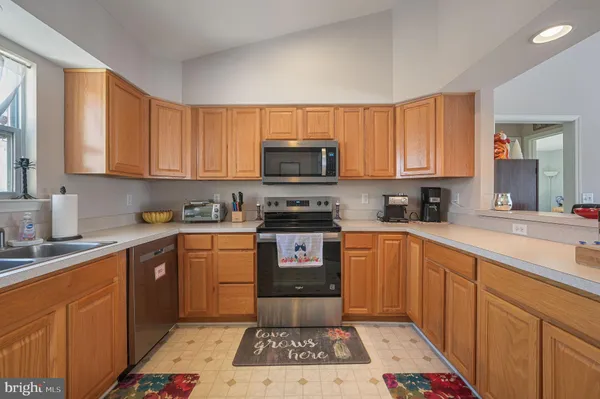 a kitchen with granite countertop a stove top oven sink and cabinets
