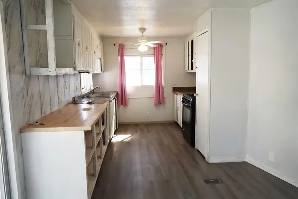 a kitchen with a refrigerator a sink and wooden floor