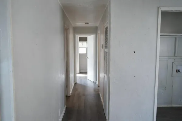 a view of a hallway with wooden floor