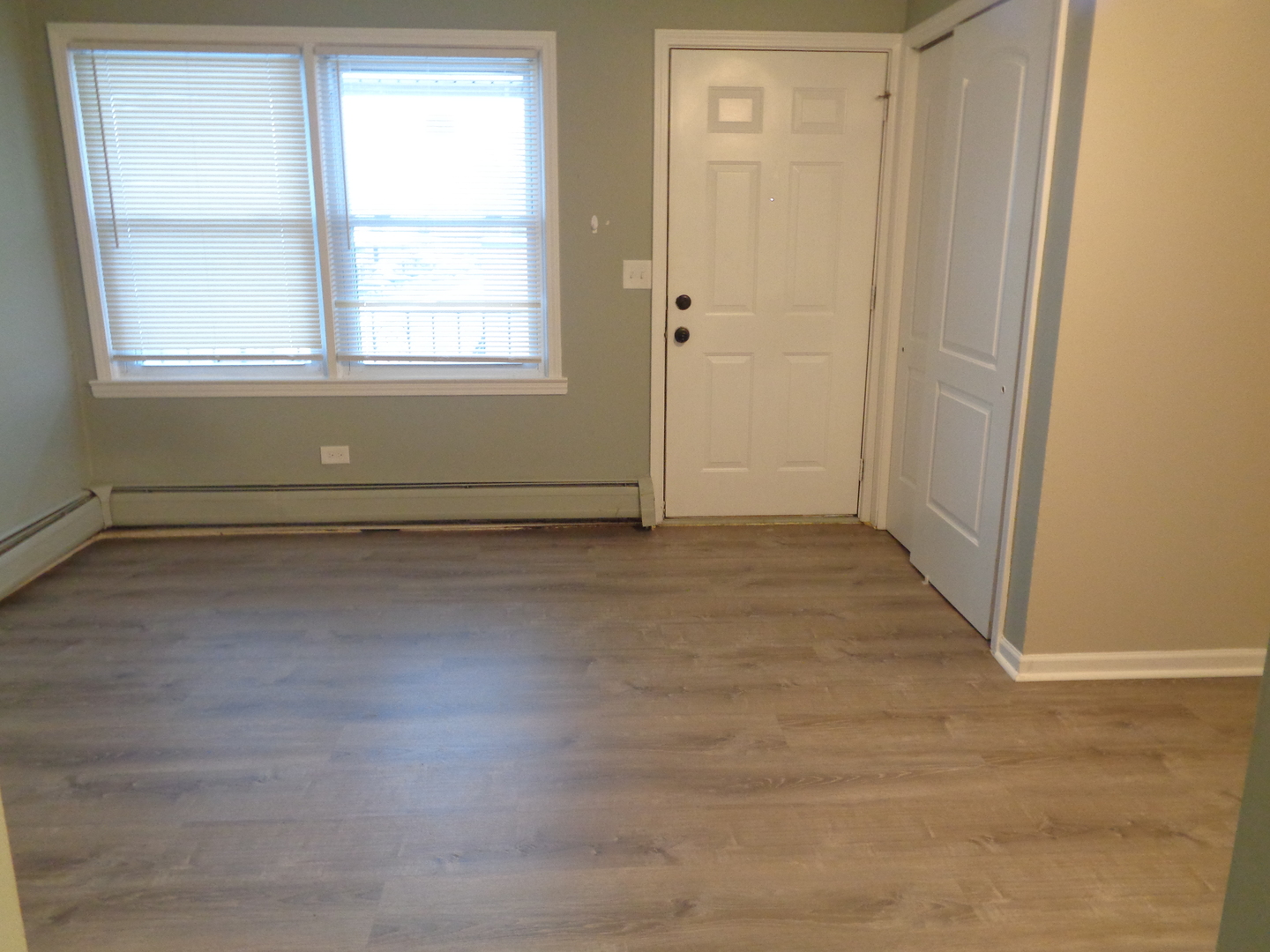 1340 North Main Street, Unit A17 Wheaton, IL 60187 - Photo 2 of 7 an empty room with wooden floor and windows