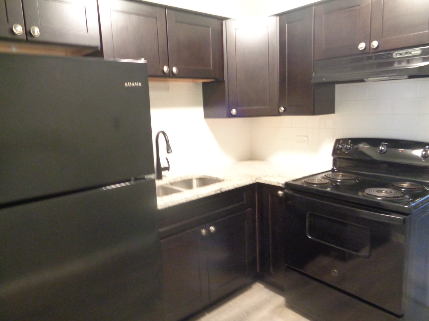 1340 North Main Street, Unit A17 Wheaton, IL 60187 - Photo 3 of 7 a kitchen with granite countertop a stove and a sink