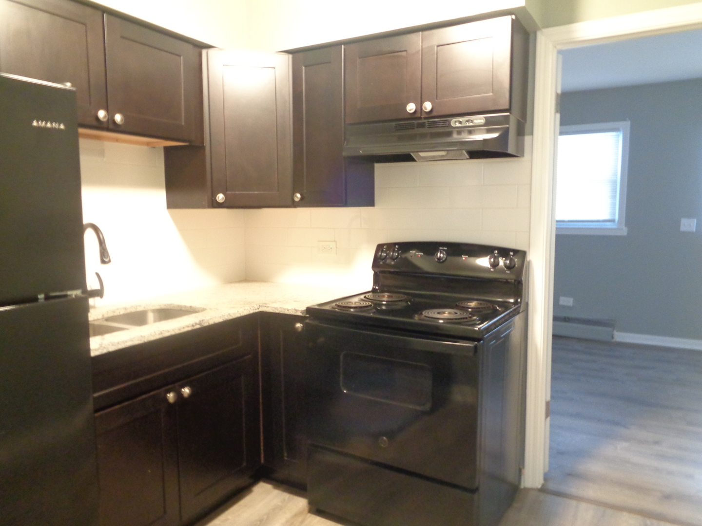 1340 North Main Street, Unit A17 Wheaton, IL 60187 - Photo 4 of 7 a kitchen with granite countertop a stove and a sink