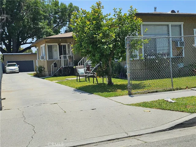 a view of a house with a yard and large tree