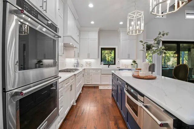 a kitchen with kitchen island white cabinets and stainless steel appliances
