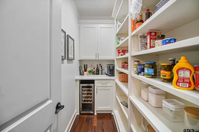 a kitchen with stainless steel appliances granite countertop a lot of cabinets and wooden floor
