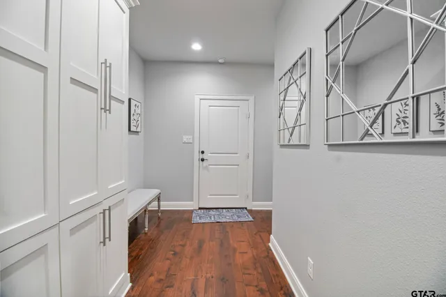 a view of hallway with walk in closet and wooden floor